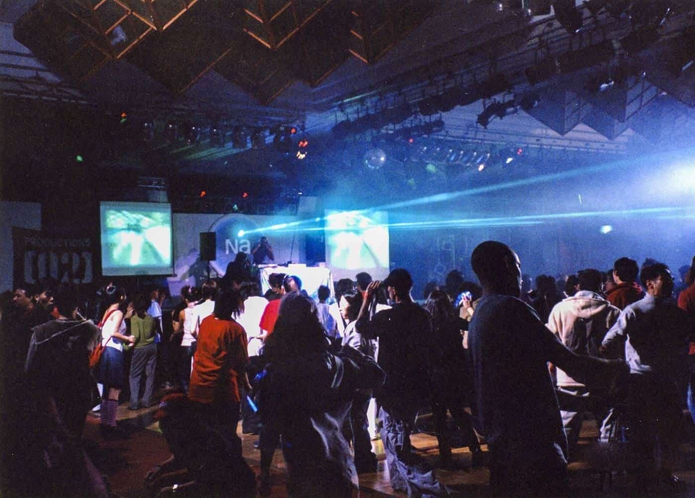 Dancers on a crowded dance floor under coloured lights